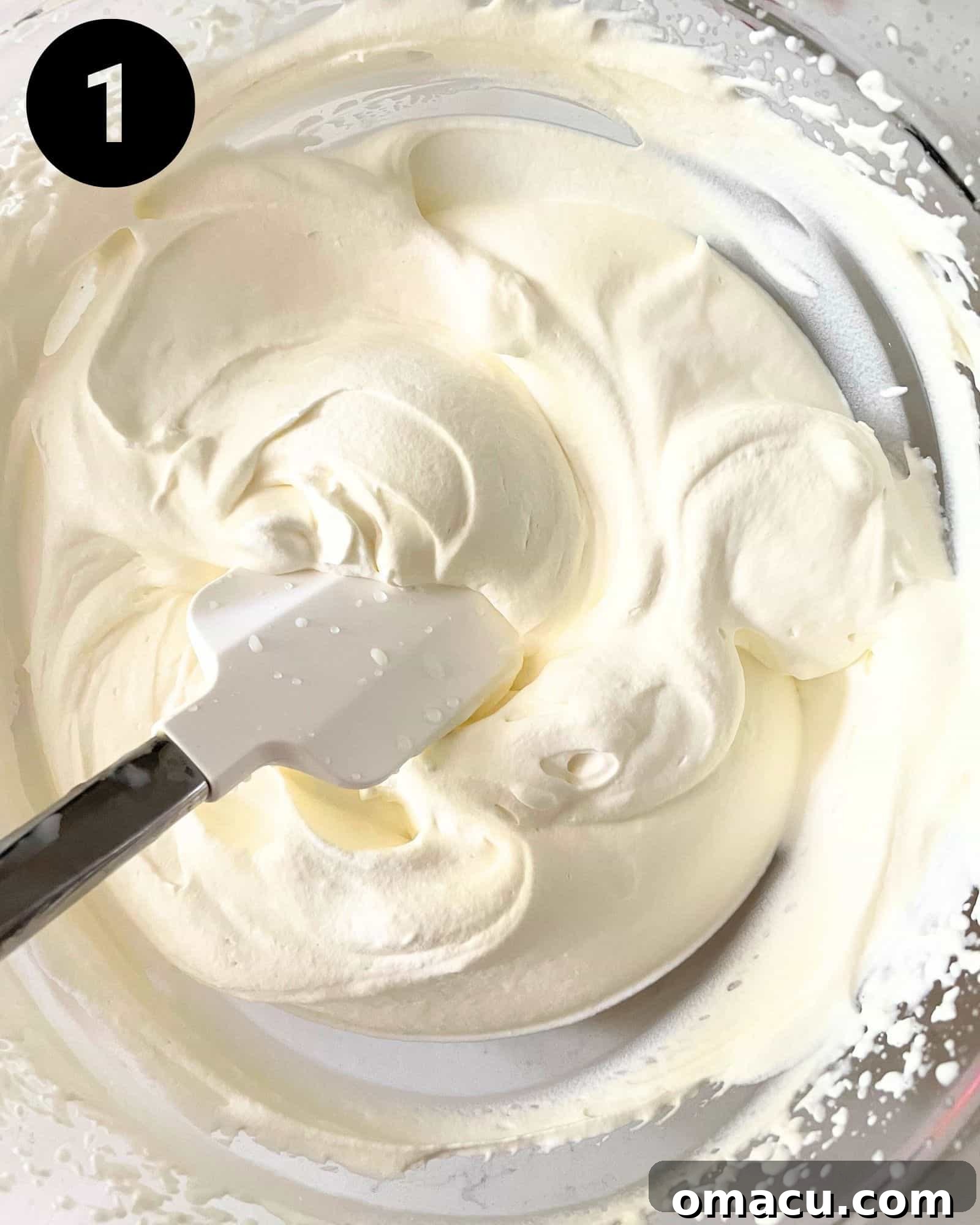 A large mixing bowl filled with light and airy whipped cream, showcasing its perfect texture before additional ingredients are folded in.