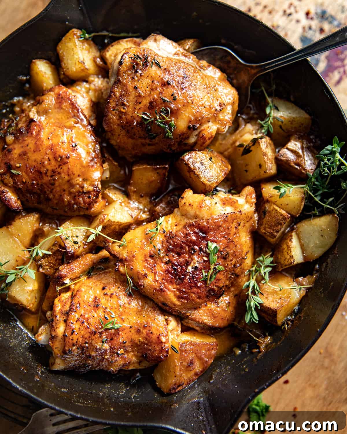 A collection of fresh ingredients for maple dijon chicken, including chicken thighs, creamer potatoes, maple syrup, dijon mustard, heavy cream, and thyme.