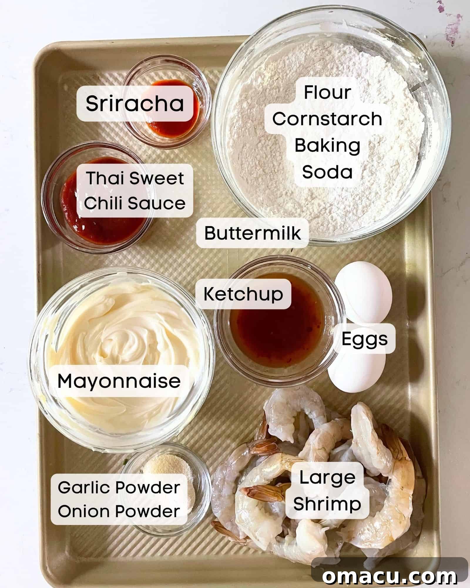 A vibrant flat lay image showcasing all the fresh ingredients required to make Boom Boom Shrimp, including large shrimp, mayonnaise, sriracha, sweet chili sauce, flour, cornstarch, baking soda, garlic powder, eggs, buttermilk, ketchup, and salt.