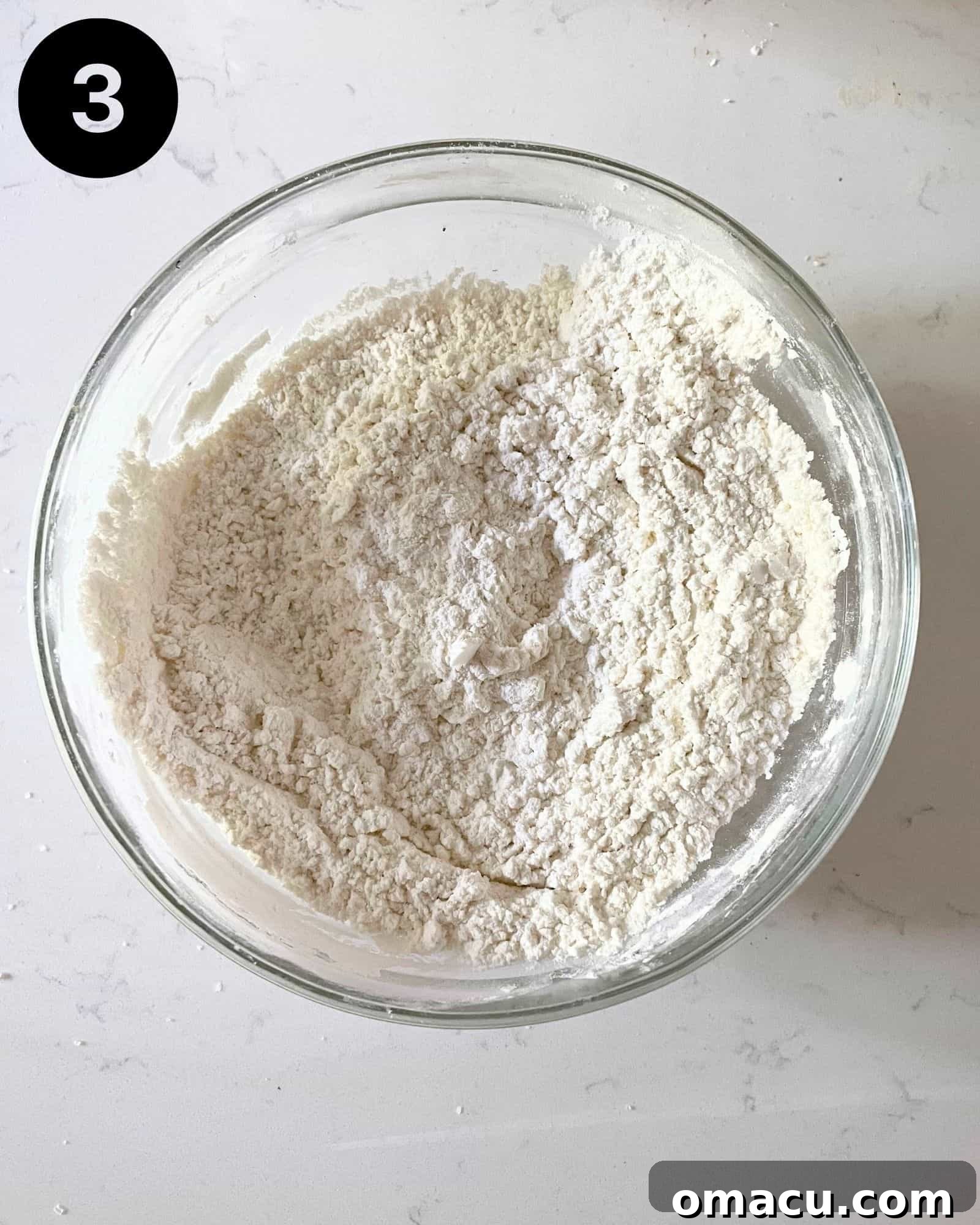 A dry flour mixture, including cornstarch and baking soda, in a bowl, ready for coating the shrimp.