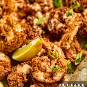Crispy Boom Boom Shrimp served in a rustic basket, generously drizzled with zesty Boom Boom sauce and garnished with fresh herbs.