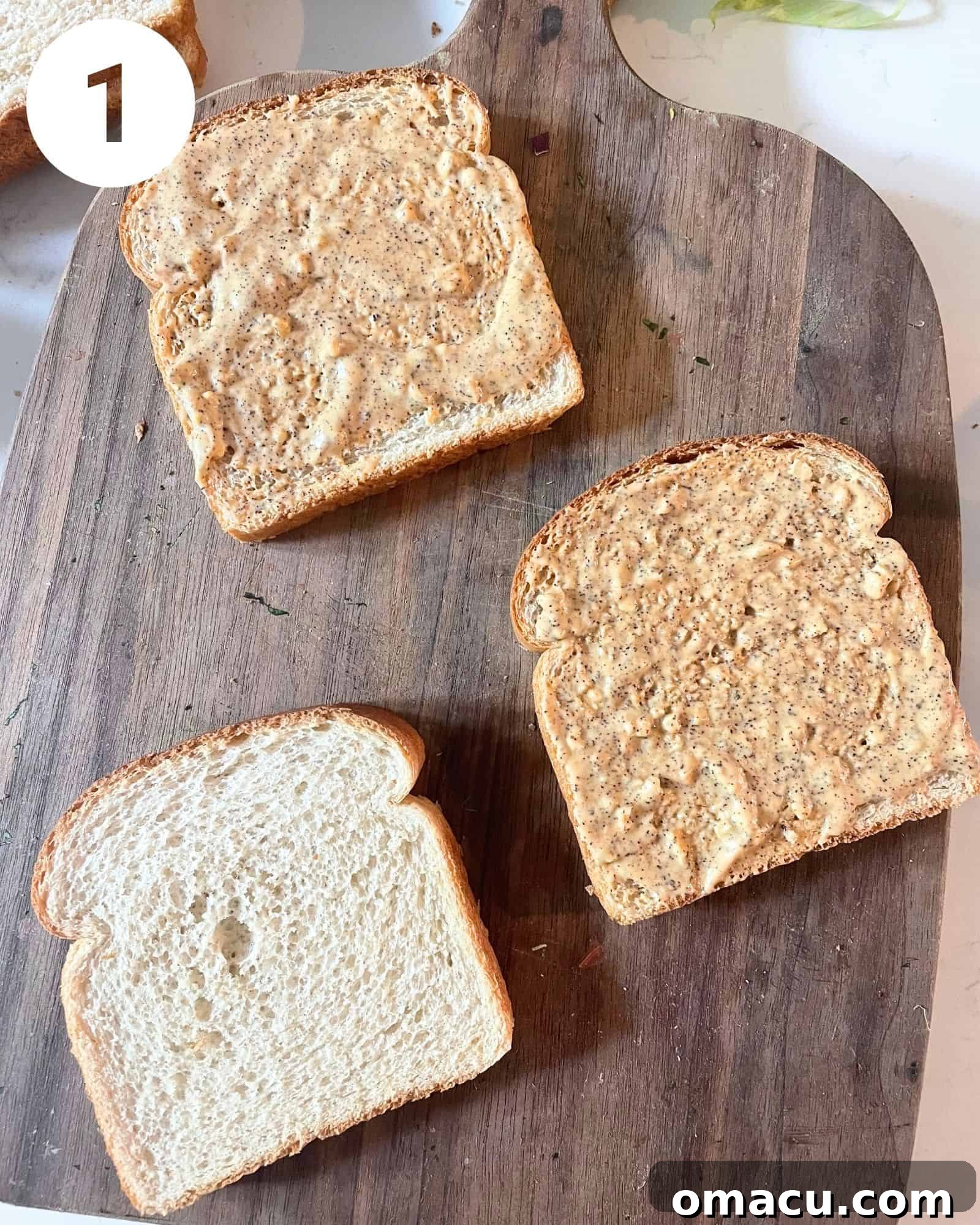 Chipotle mayo being spread evenly onto a slice of golden-brown toasted bread.