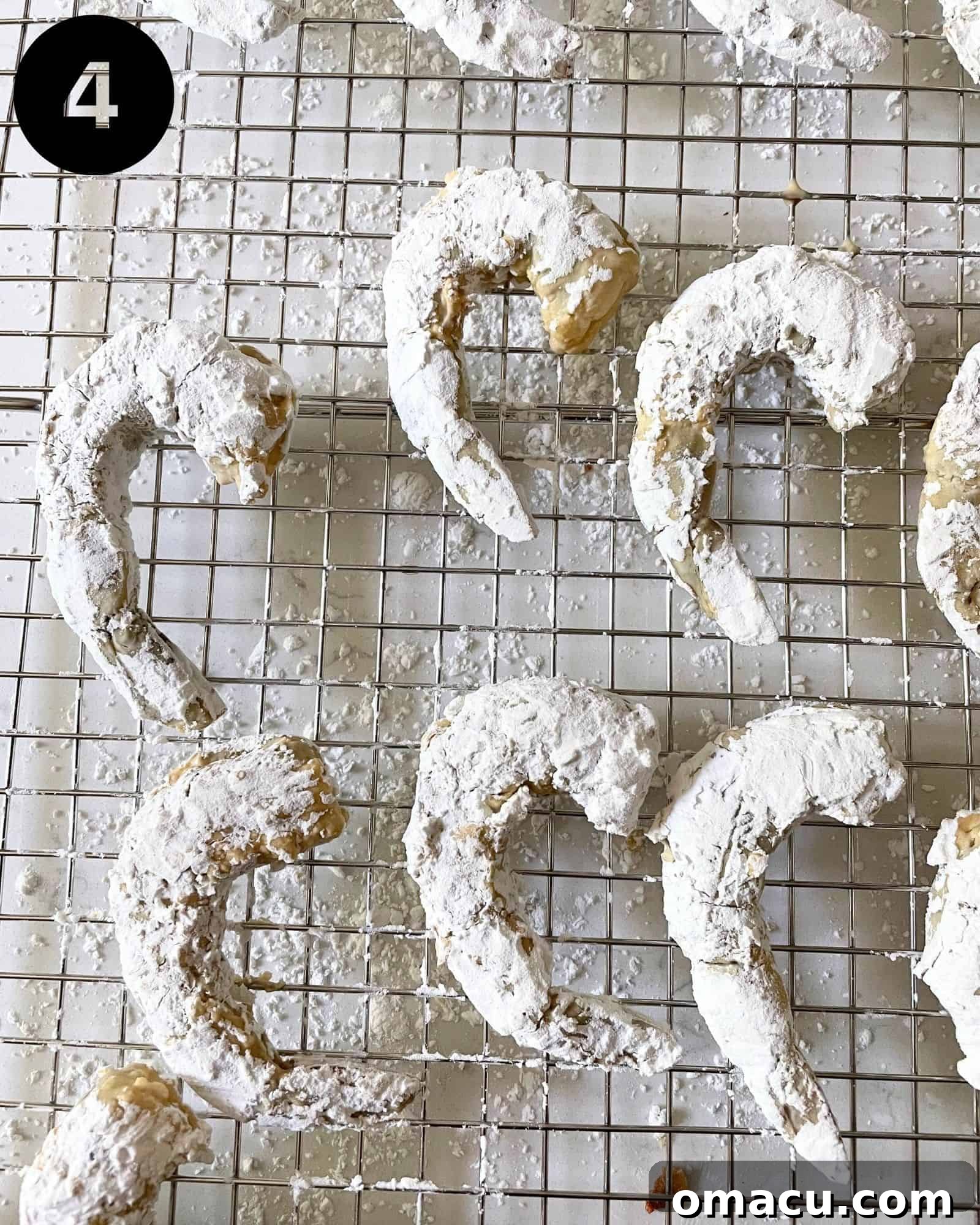 Shrimp coated evenly in cornstarch, resting on a wire rack, prepared for deep-frying to achieve a crispy texture.