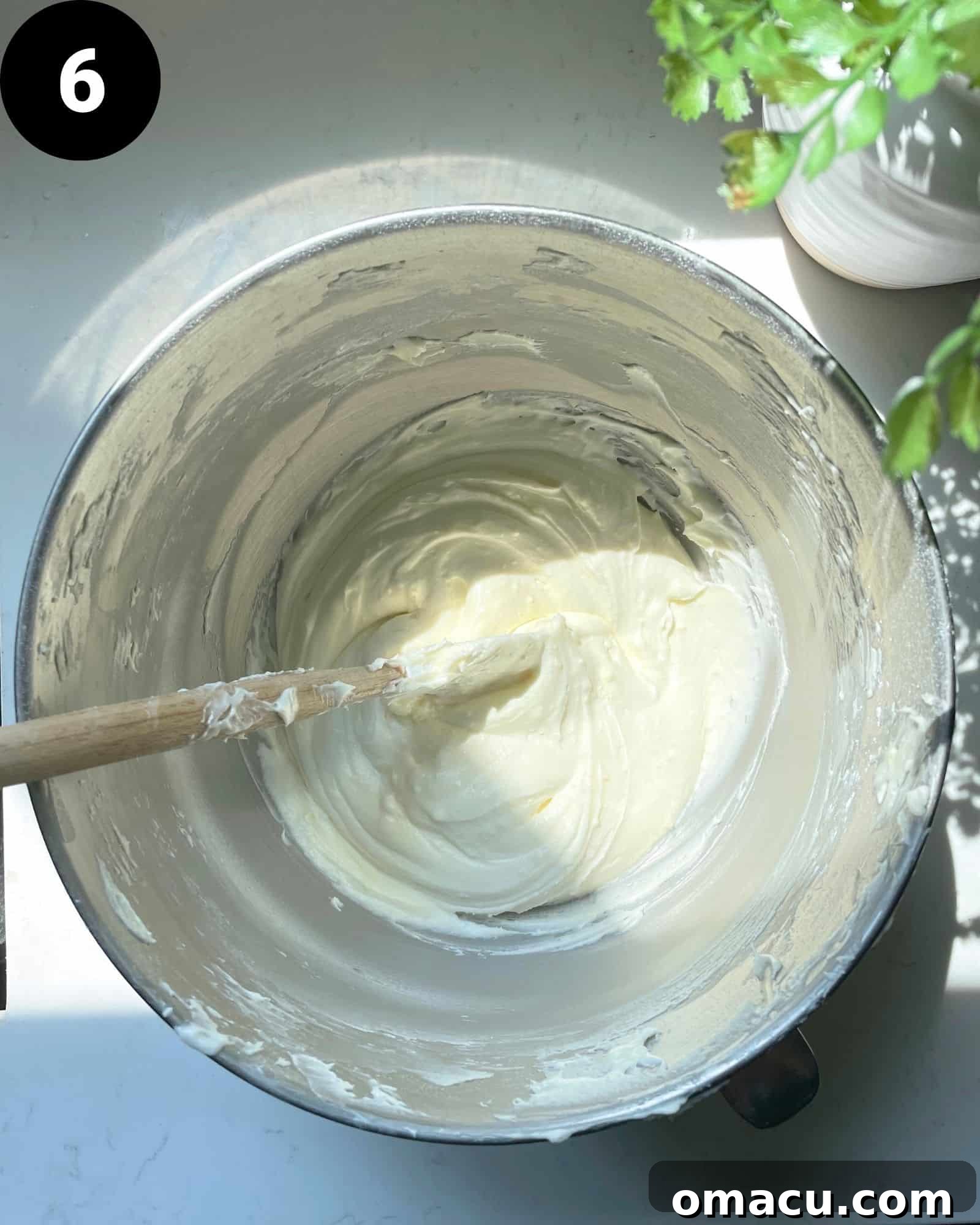 Smooth and fluffy lemon cream cheese frosting in a mixing bowl, ready for application.