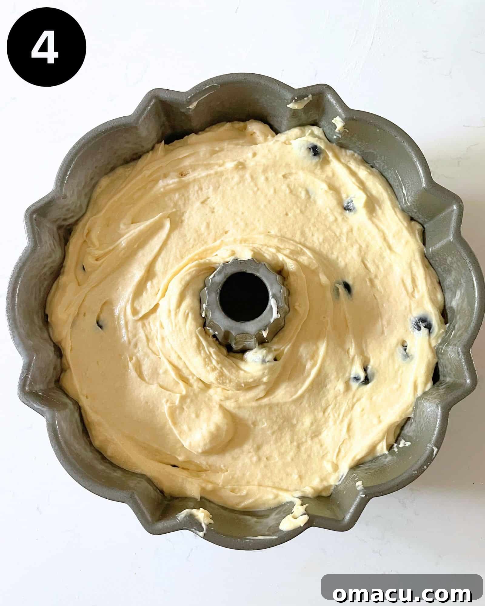 Blueberry pound cake batter expertly poured into a bundt pan, ready for baking.