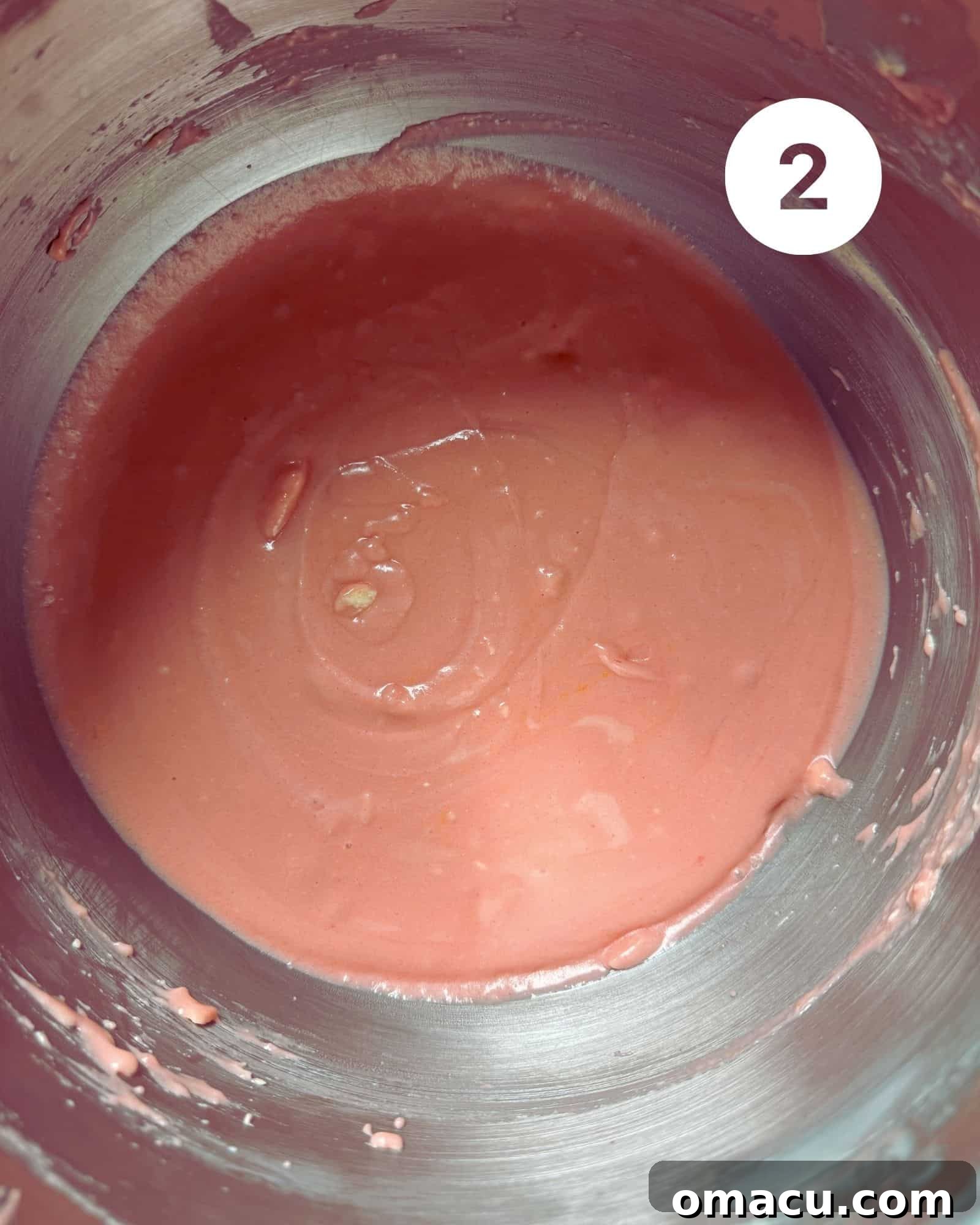 Smooth and creamy pound cake batter being mixed in a gleaming silver stand mixer bowl, showing its light texture.