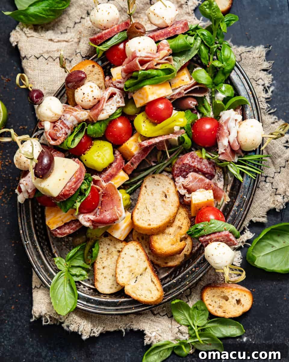 Beautifully arranged charcuterie skewers on a serving plate, accompanied by crackers and fresh rosemary for garnish.