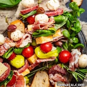 charcuterie skewers garnished with fresh herbs.