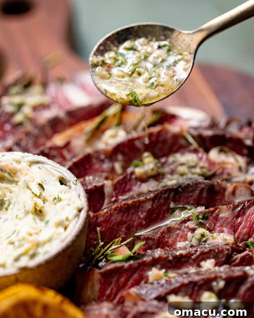 Melted steak butter being poured onto a steak with a spoon, showing its rich, glossy texture.
