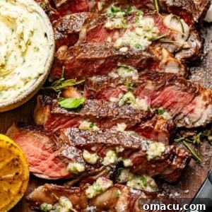sliced steak on a cutting board with a bowl of steak butter.
