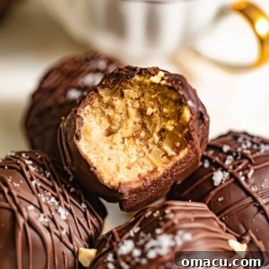 Peanut butter truffles in a pile with one bitten into.