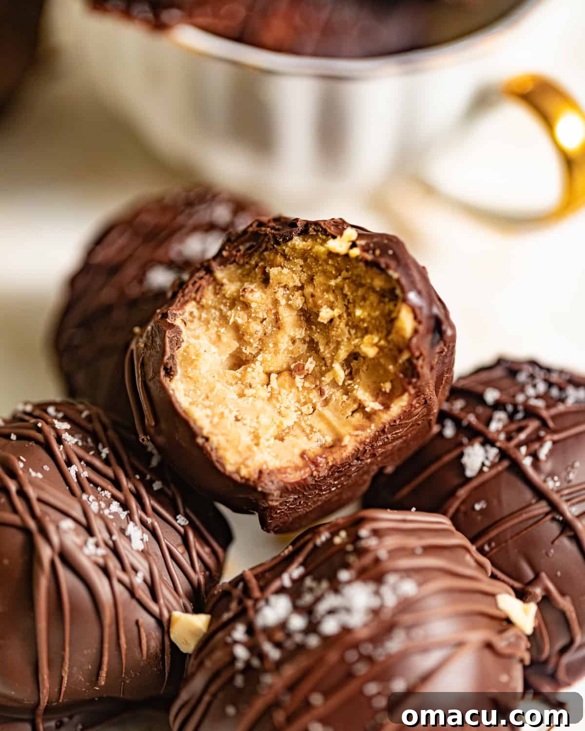 Peanut butter truffles in a pile with one bitten into.