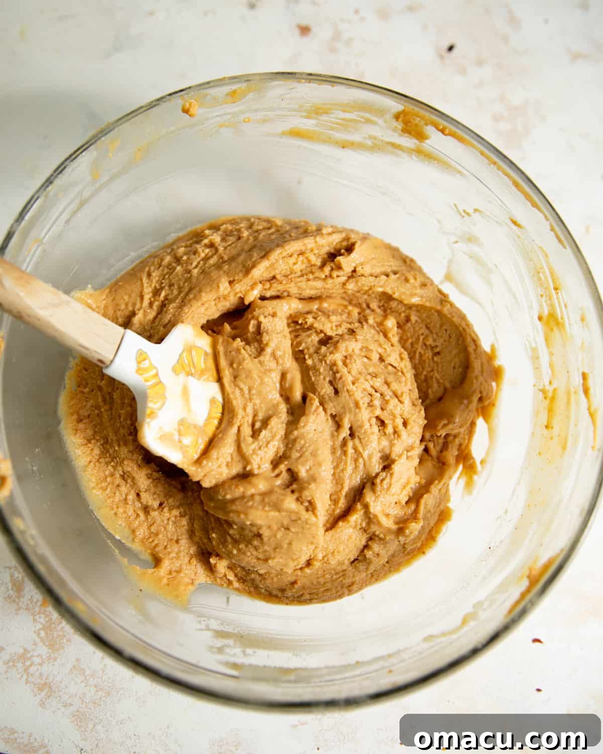 A spatula in a mixing bowl of peanut butter truffle filling.