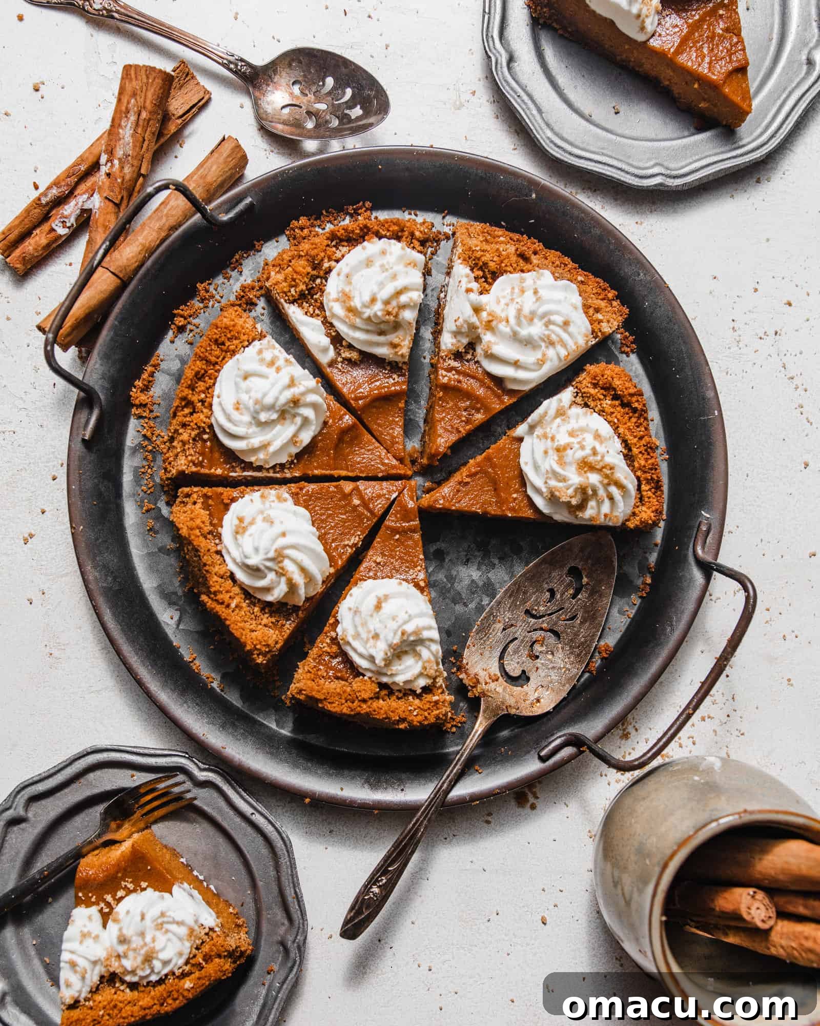 sliced sweet potato pie on a serving tray with a pie server and slices of pie on smaller plates