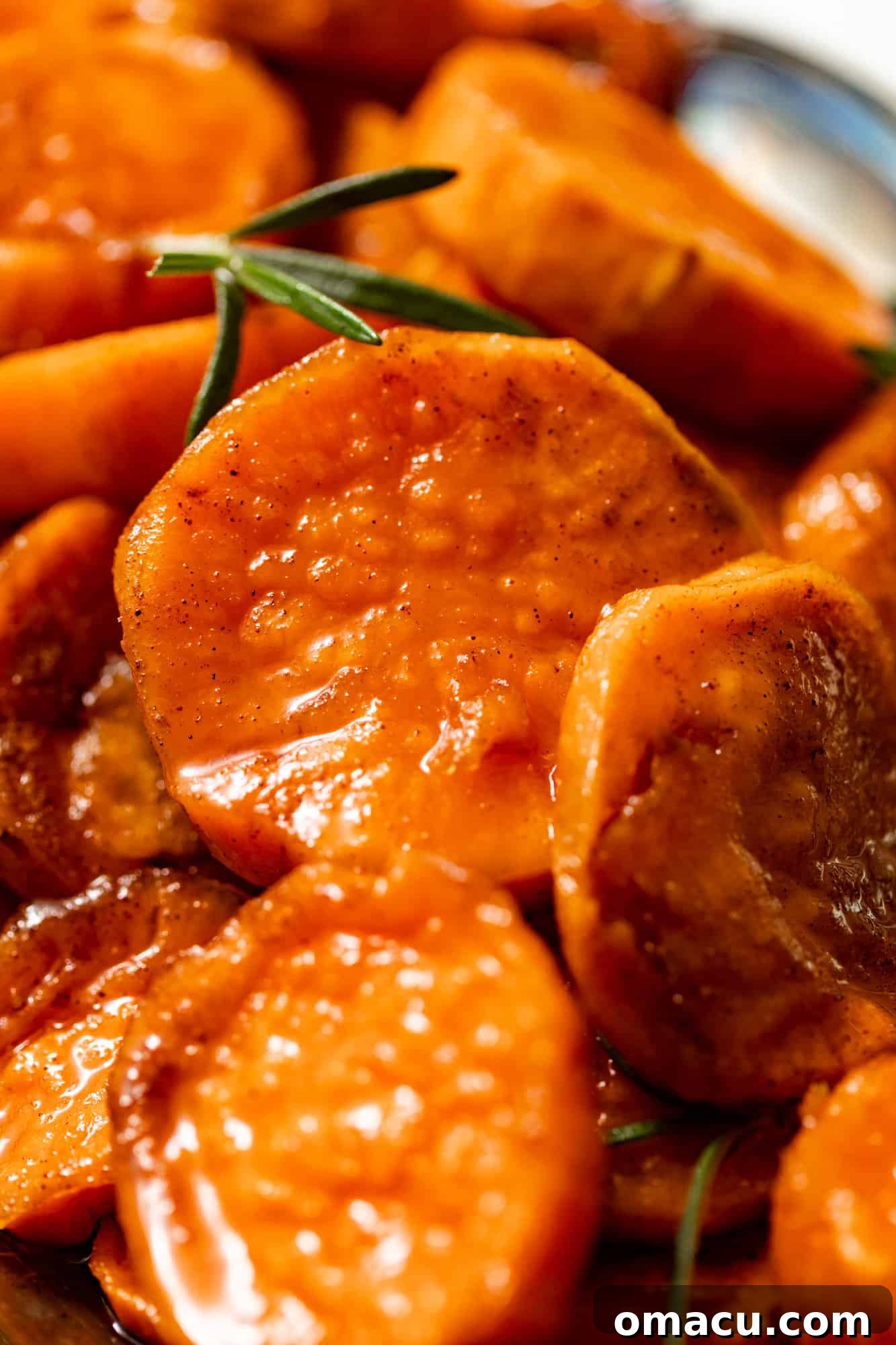 Close-up photo of glistening stovetop candied yams covered in a rich brown sugar glaze, ready to be served.