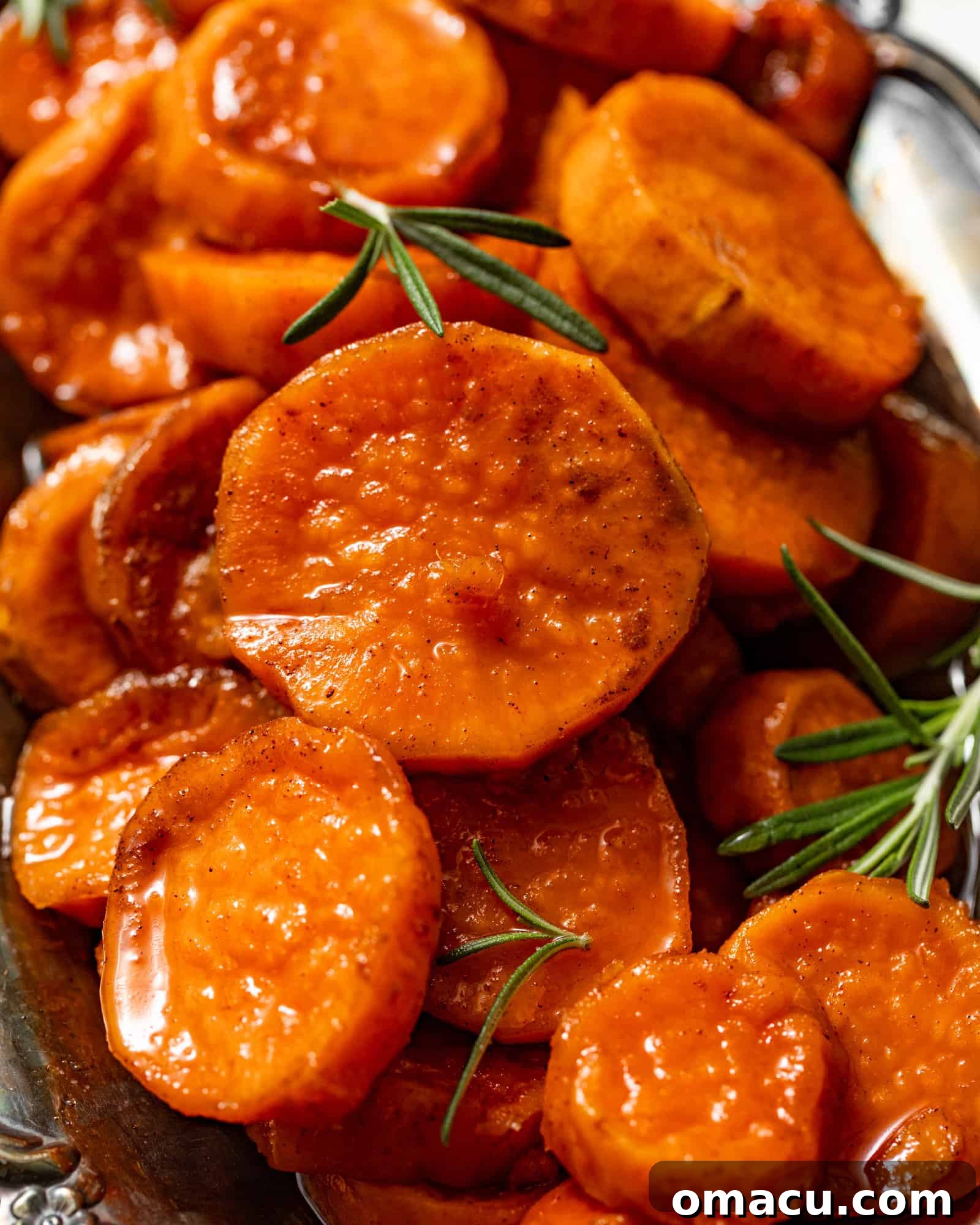 A serving tray filled with beautifully sliced, glossy sweet potatoes, generously covered in the rich, sweet syrup.