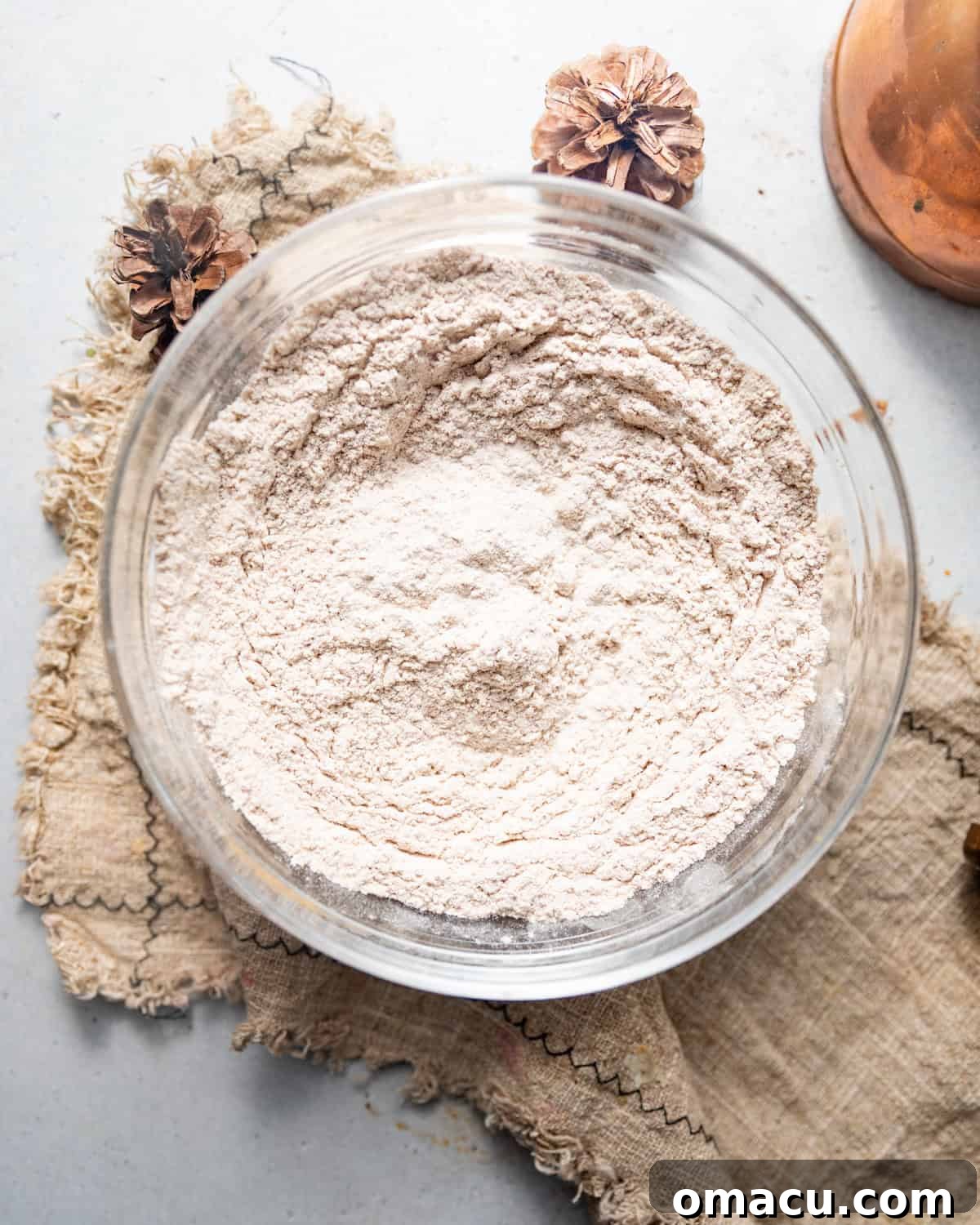 All the dry ingredients, including flour, spices, baking soda, and salt, are whisked together in a large mixing bowl.