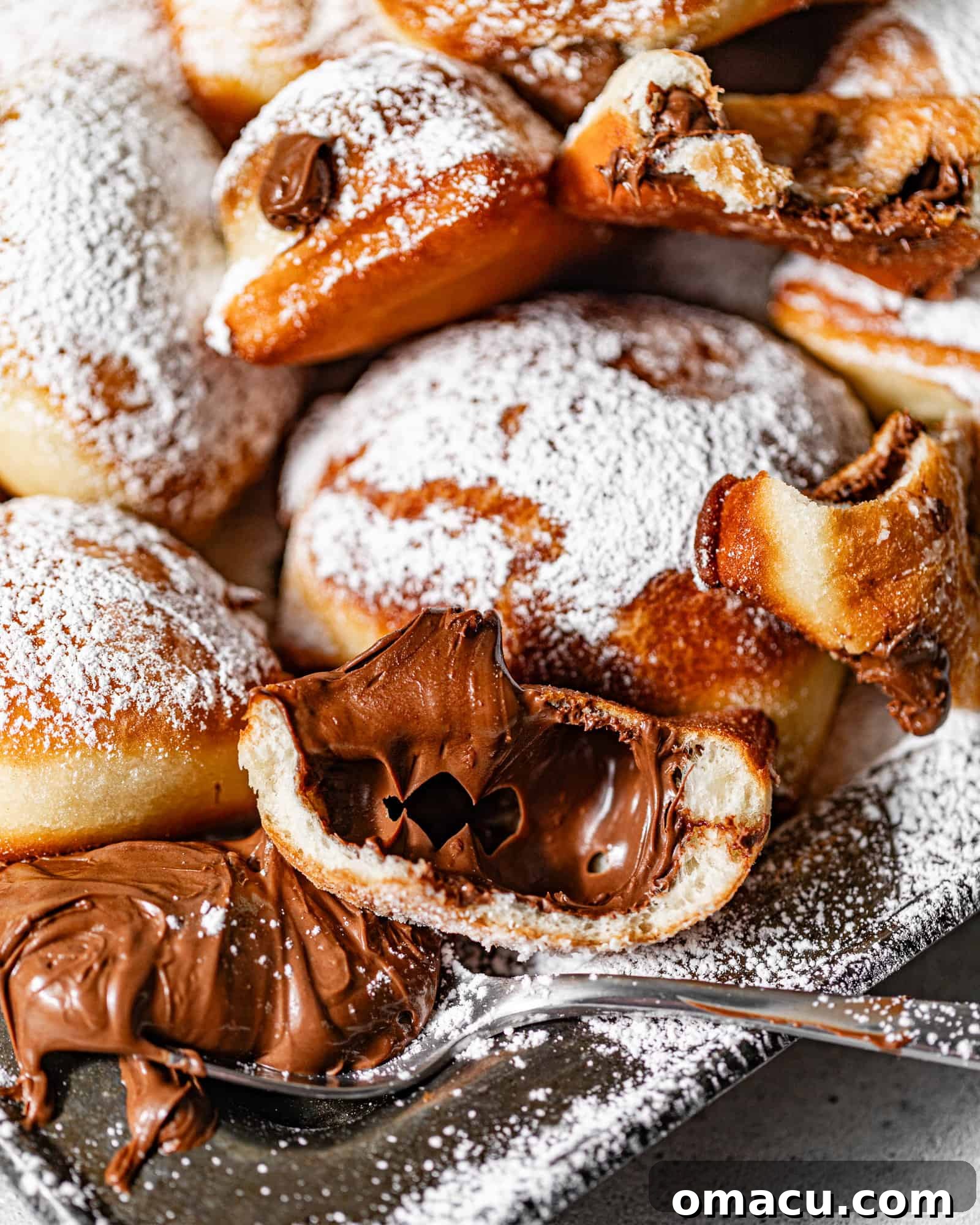 A Nutella beignet cut in half showing the Nutella stuffed center.