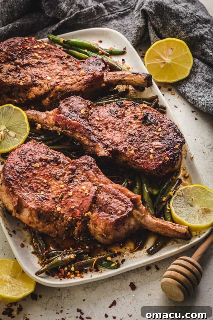 Close-up of juicy Honey Soy Garlic Pork Chops resting on a cutting board, highlighting their tender texture.