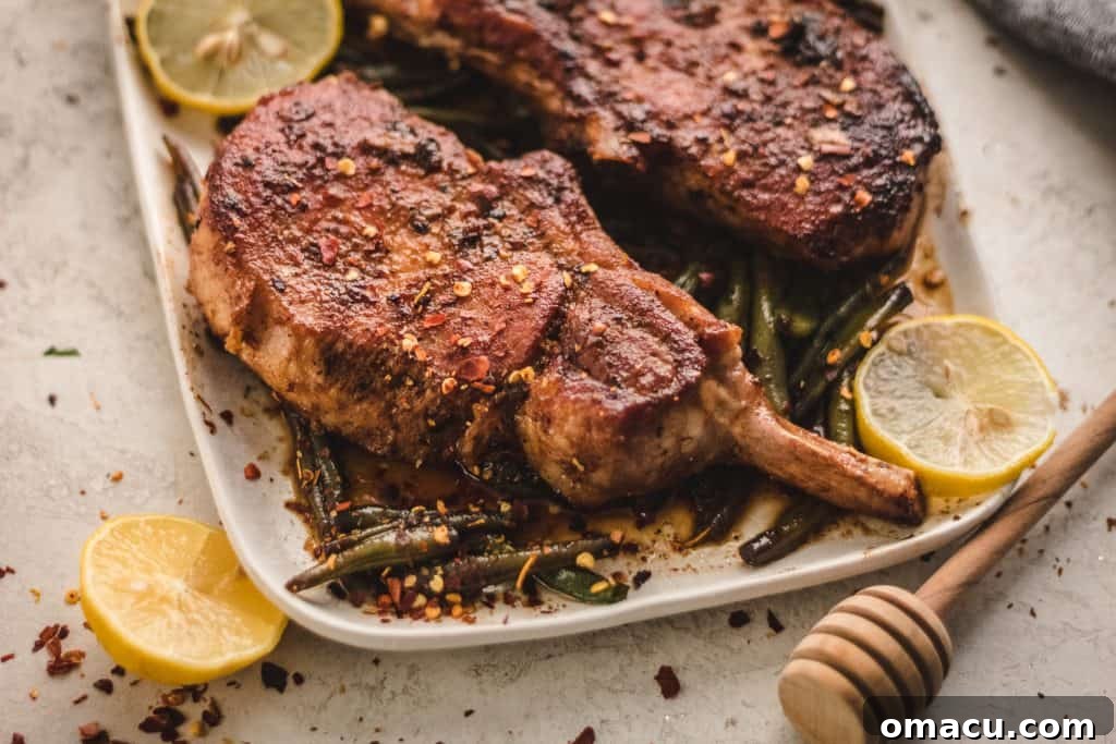 Crispy edges of seared pork chops in a cast iron pan, glistening with the honey soy garlic glaze.