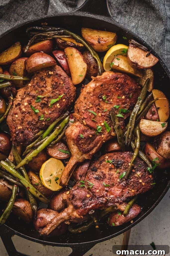 The finished Honey Soy Garlic Pork Chops simmering in their rich sauce in a cast iron skillet.
