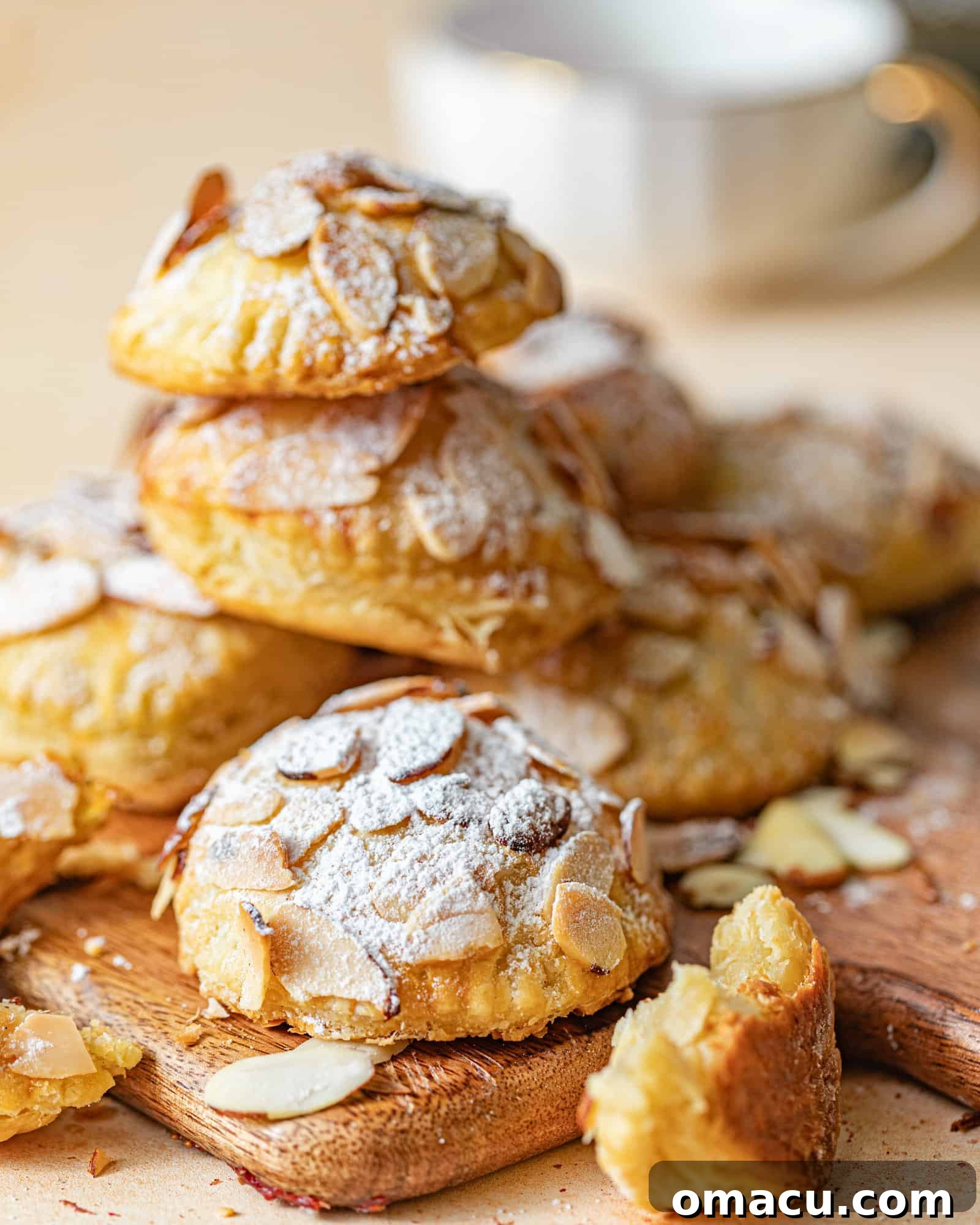 croissant cookies on a serving board with a coffee cup in the background.