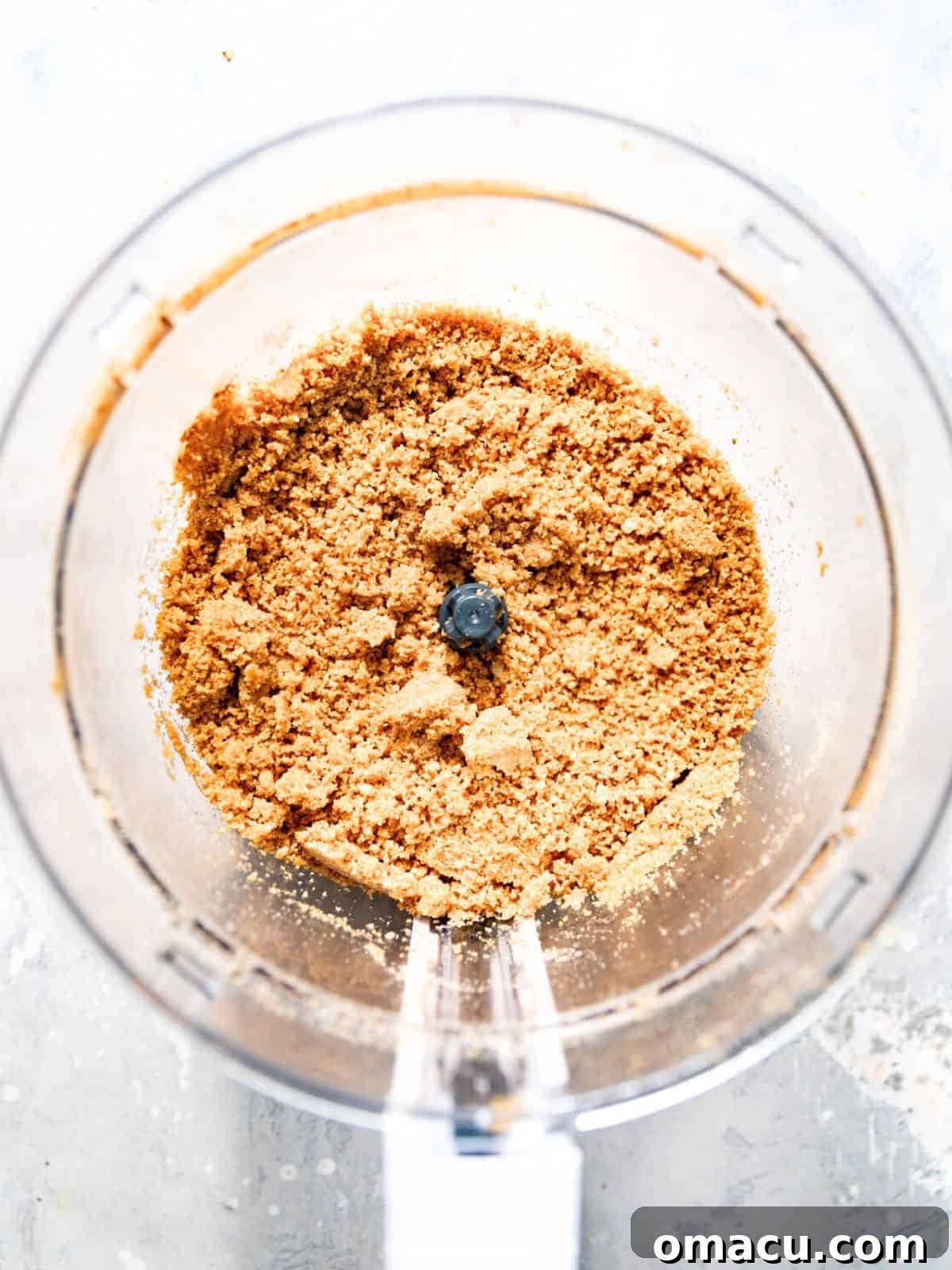 Graham crackers being crushed into fine crumbs in a food processor.