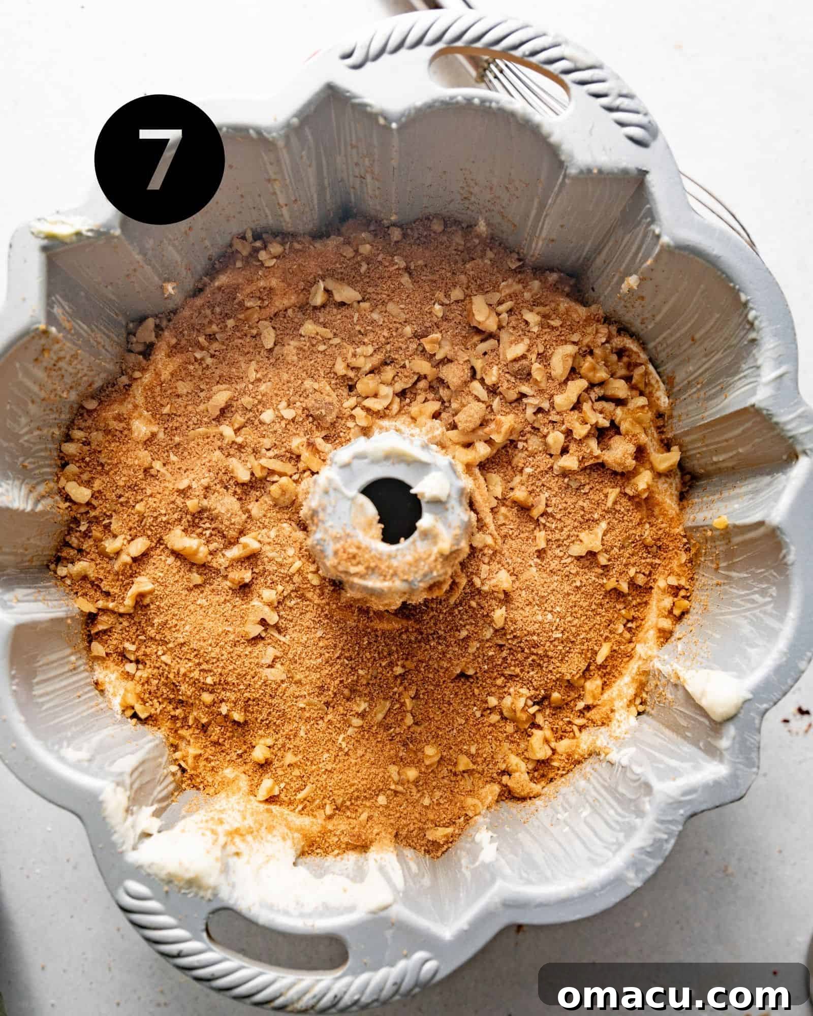 A layer of cinnamon pecan filling carefully sprinkled onto the cake batter in the bundt pan.