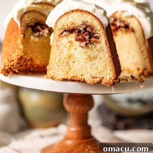 sock it to me cake on a cake stand sliced to show the inner pecan streusel.