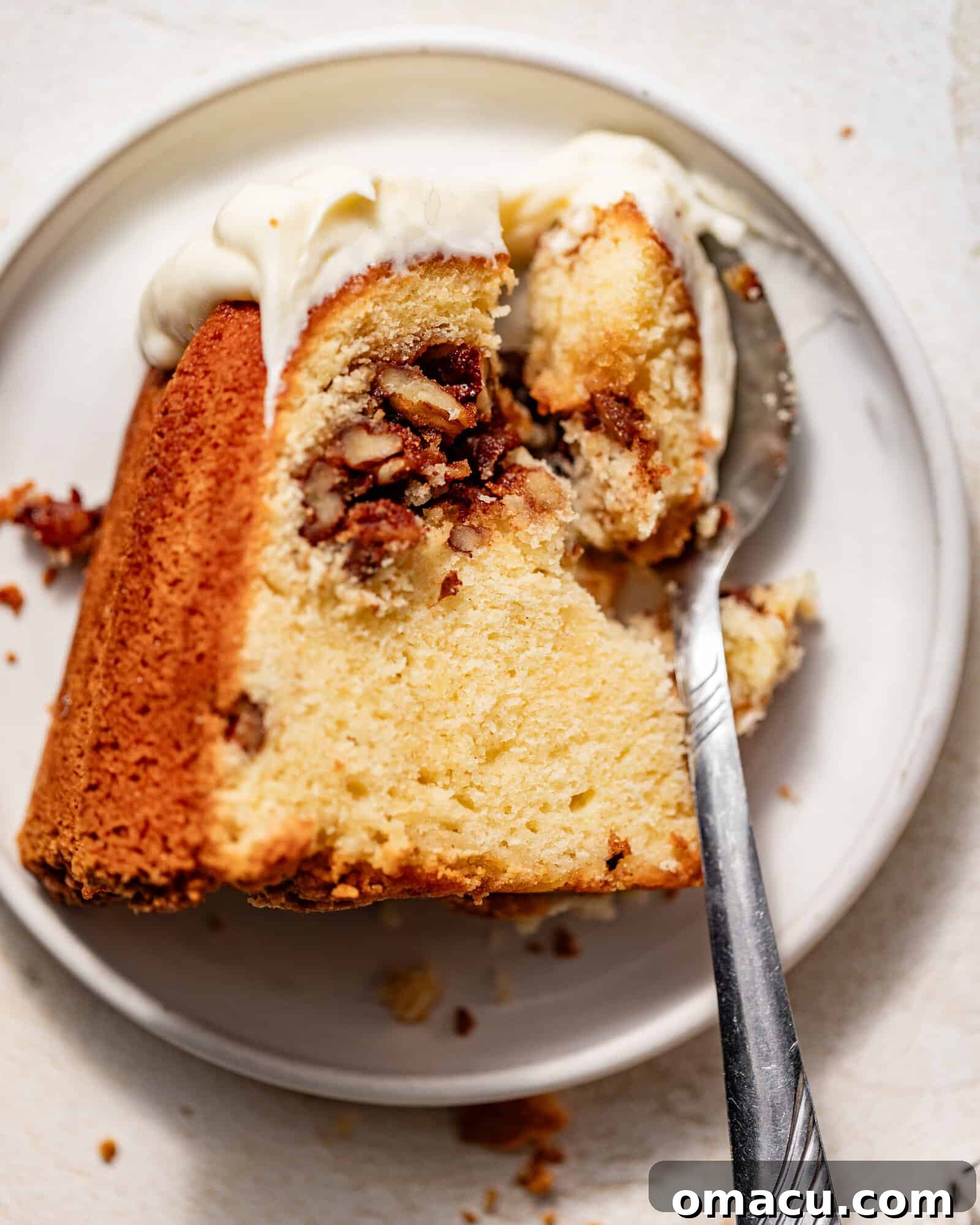 A tempting slice of Sock it to Me Cake presented on a plate with a spoon, ready to be enjoyed.