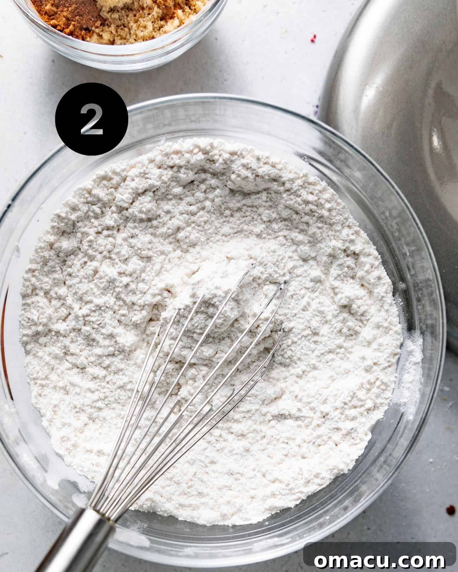 A mixing bowl containing cake flour, baking soda, nutmeg, and kosher salt, perfectly whisked together.