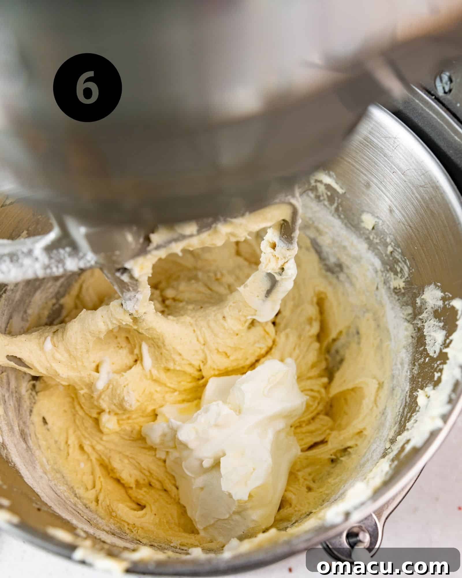 Sock it to Me Cake batter in a stand mixer, showcasing the creamy texture after sour cream has been added.