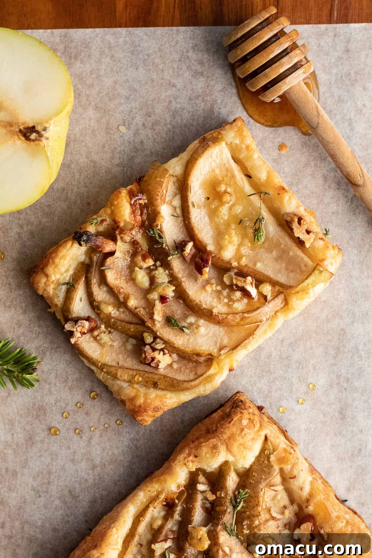 Overhead shot of a platter of warm pear and gorgonzola puff pastry appetizers, artfully arranged for a party.