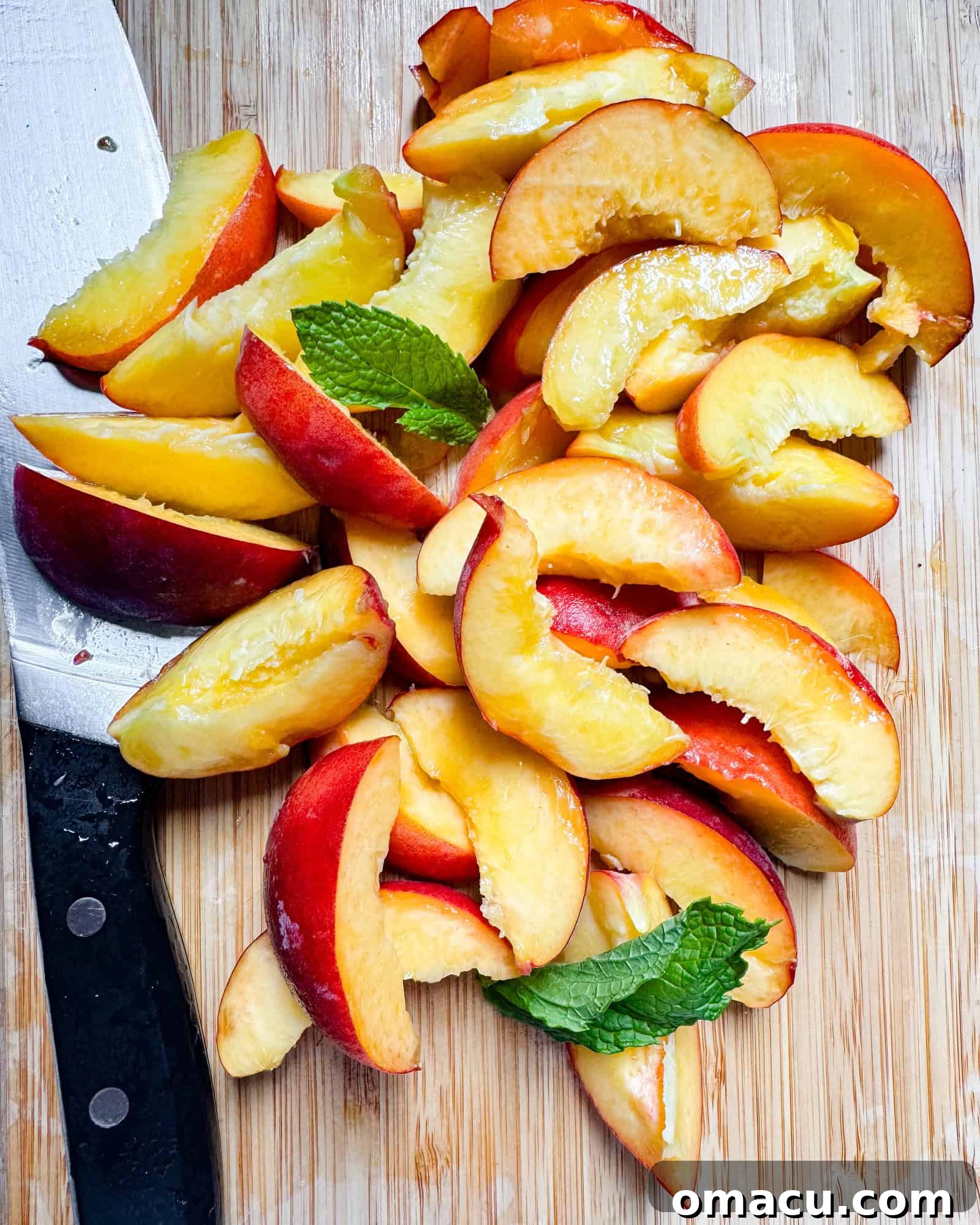 Thinly sliced ripe peaches arranged neatly on a cutting board, ready for syrup preparation.