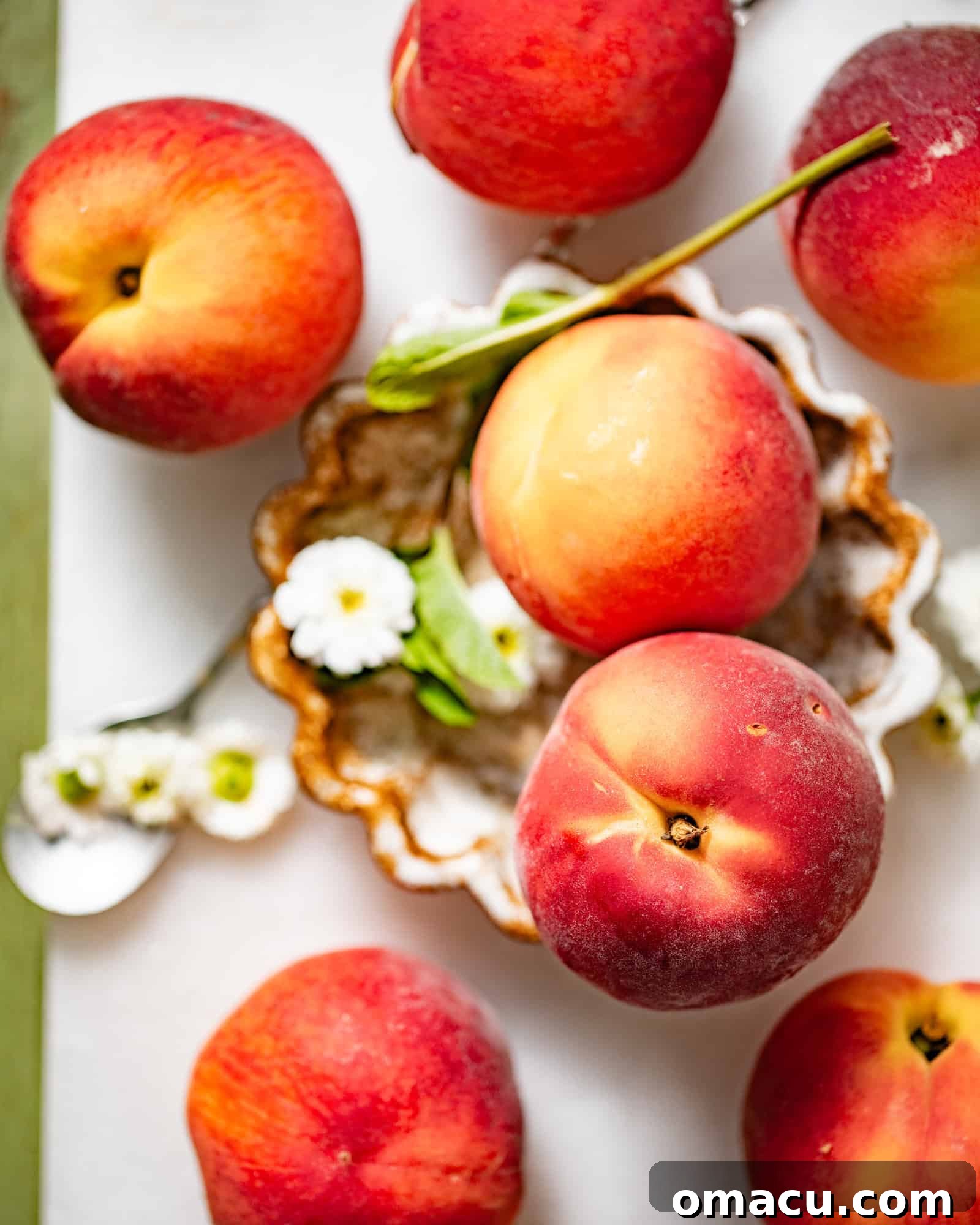 Close-up of vibrant, ripe fresh peaches arranged beautifully on a rustic wooden cutting board, complemented by delicate edible flowers, emphasizing the natural allure of the fruit.