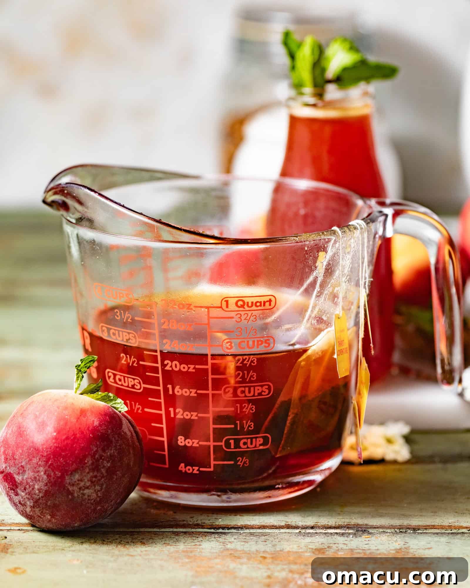 Black tea bags steeping vigorously in a large transparent measuring cup filled with boiling hot water, vividly illustrating the essential tea brewing process.