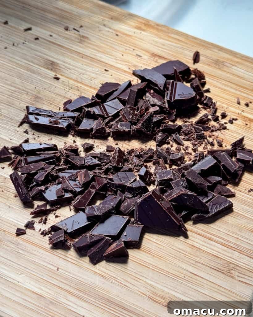 Chopped dark chocolate on a cutting board.