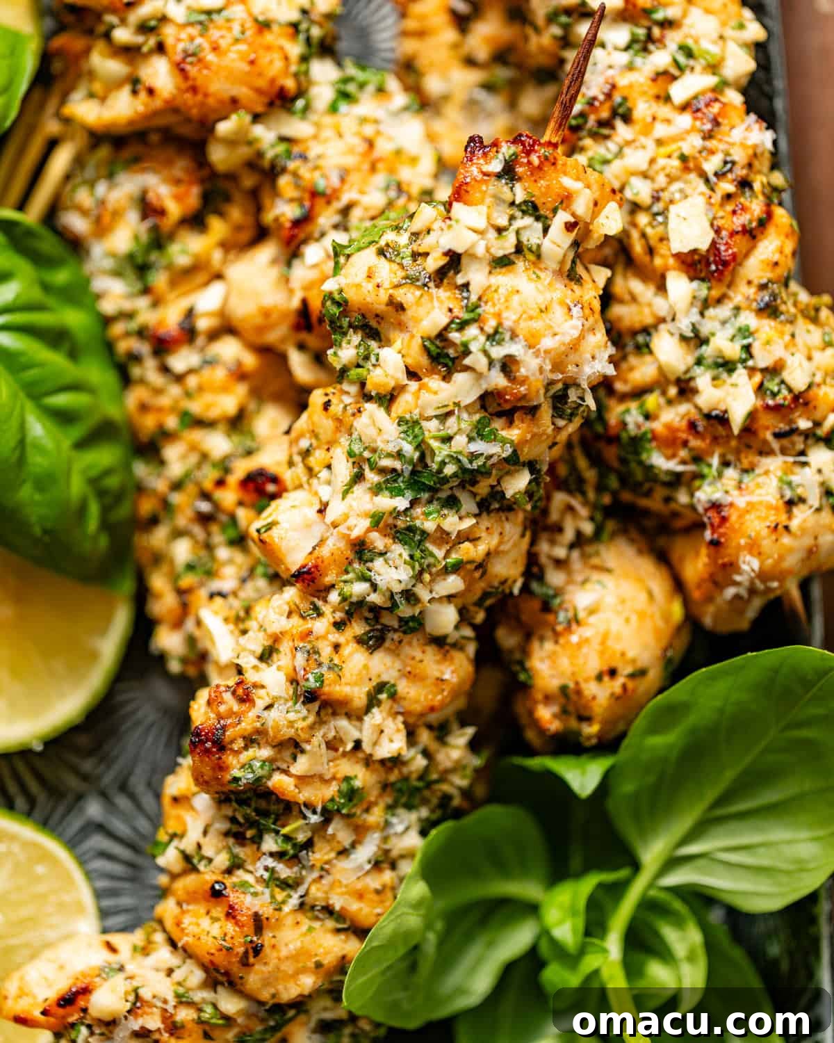 Garlic Parmesan Chicken Skewers artfully arranged on a serving plate, garnished with fresh basil and vibrant lemon slices.