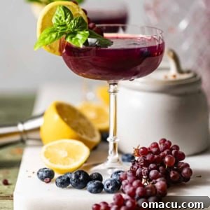 blueberry lemon drop martini on a white serving tray with fresh blueberries, lemons, and grapes.