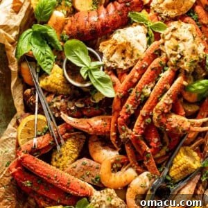 A vibrant seafood boil with crab legs, shrimp, lobster, corn, sausage, and potatoes, drenched in sauce.