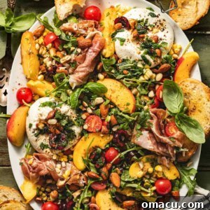 burrata arugula salad with peaches, cherries, avocado, and fresh basil on a serving plate.