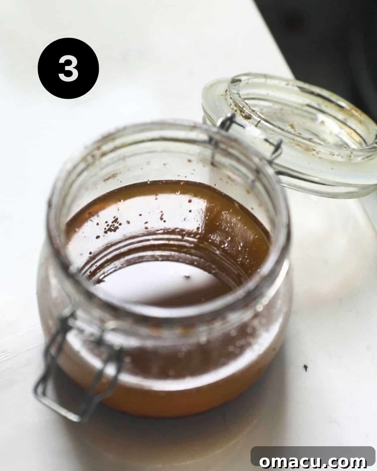 Homemade apricot vinaigrette mixed vigorously in a glass jar, showing its emulsified texture.