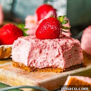 strawberry cheesecake bar on a cutting board with a bite taken out of it.