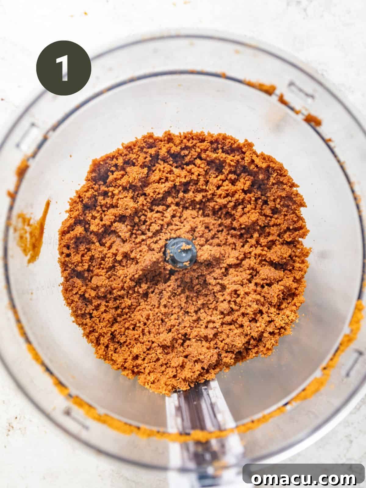 biscoff cookies and melted butter in a food processor to make the cheesecake bar crust.