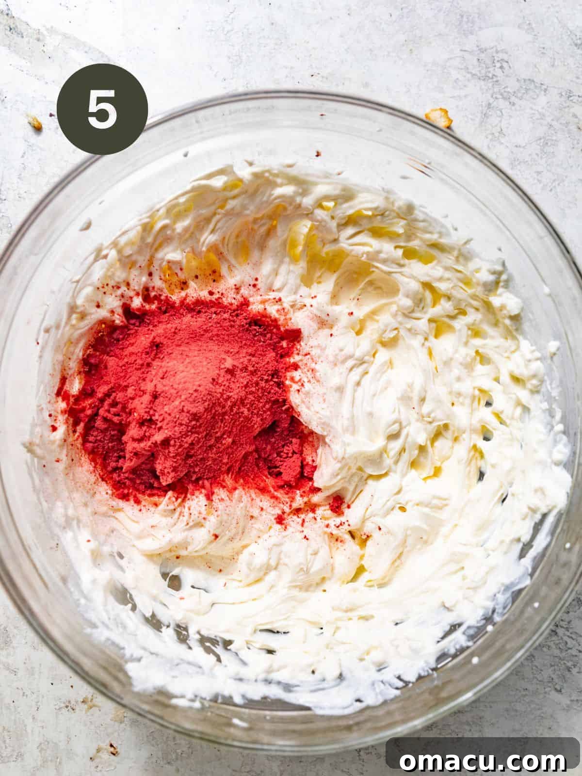 freeze dried strawberries in a mixing bowl with whipped cream.