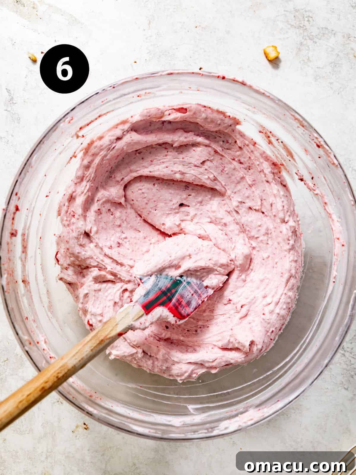 strawberry cheesecake bar filling in a bowl with a flat spatula.