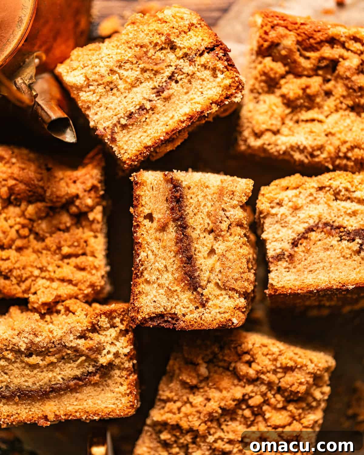 cardamom coffee cake cut into squares and scattered about on a piece of parchment paper.
