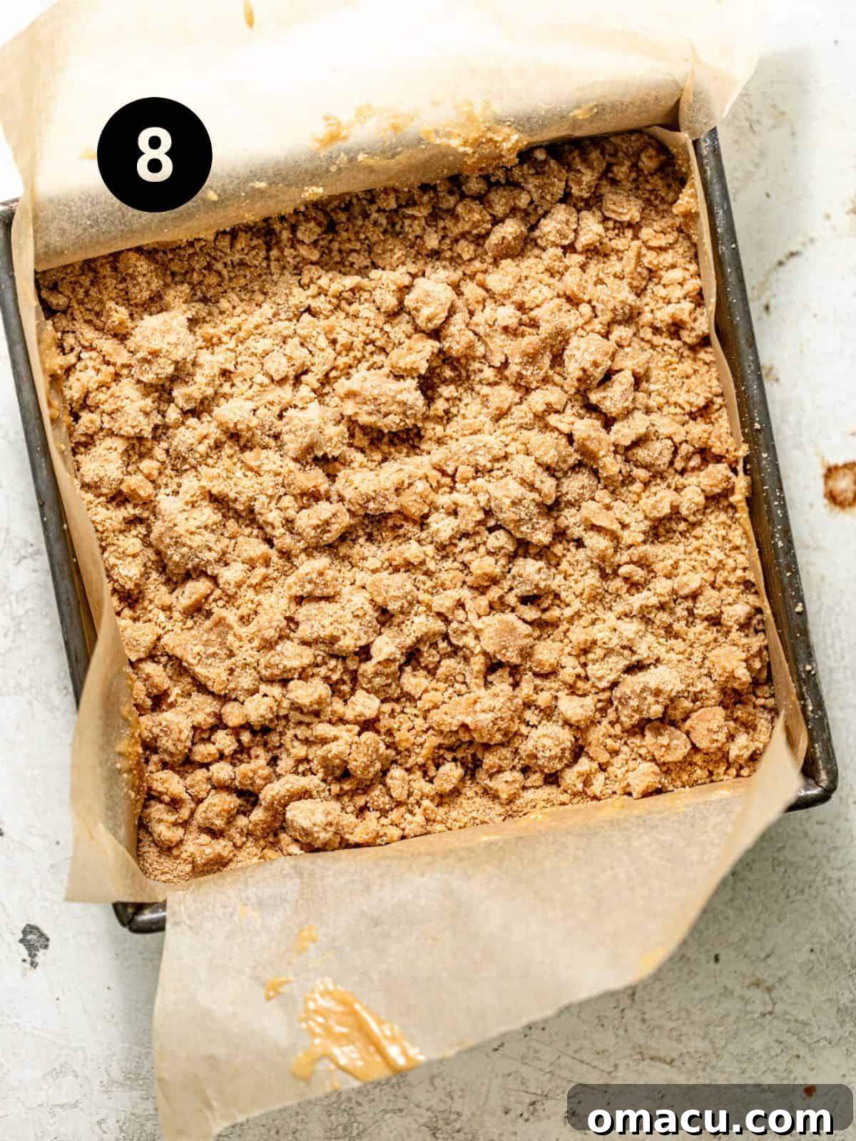 cardamom coffee cake batter assembled in a parchment lined square baking pan. 