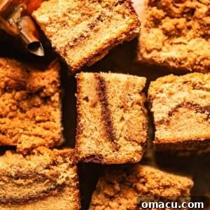 cardamom coffee cake cut into squares and scattered about on a piece of parchment paper.