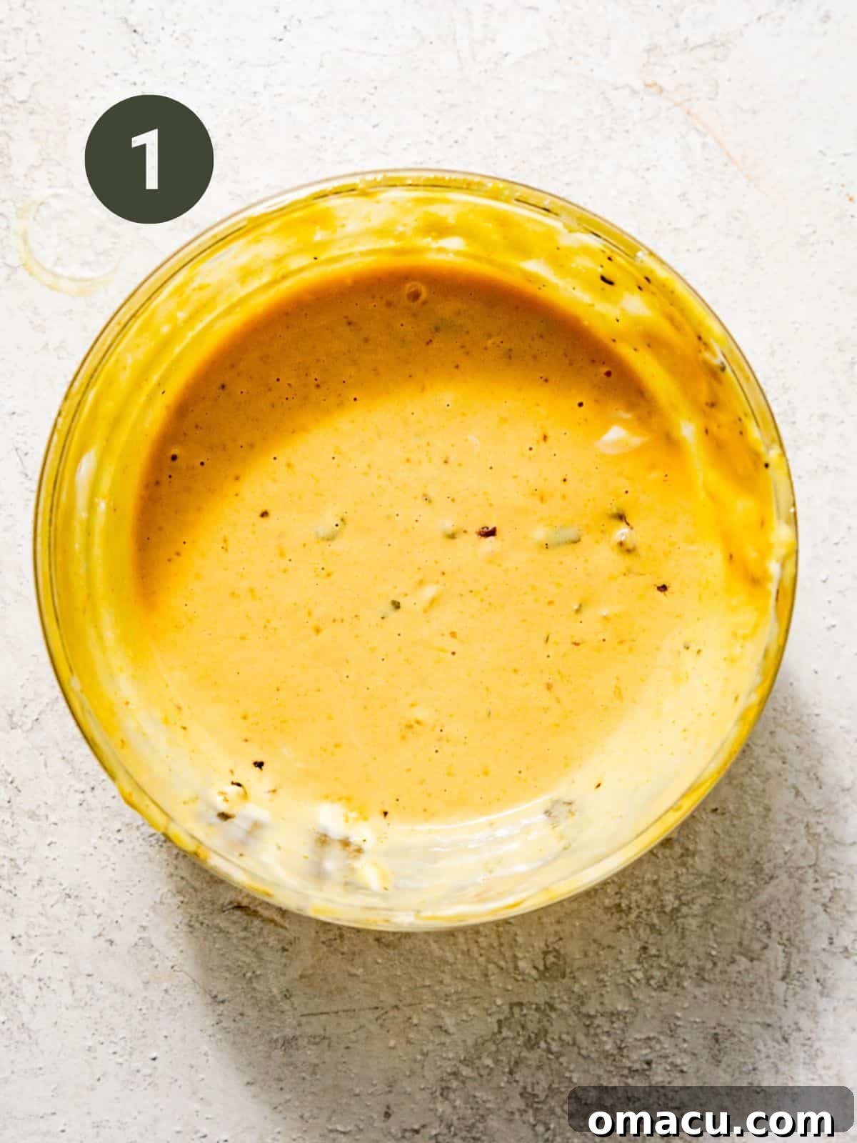 Burger sauce ingredients whisked together in a small mixing bowl, showing a smooth, creamy texture.